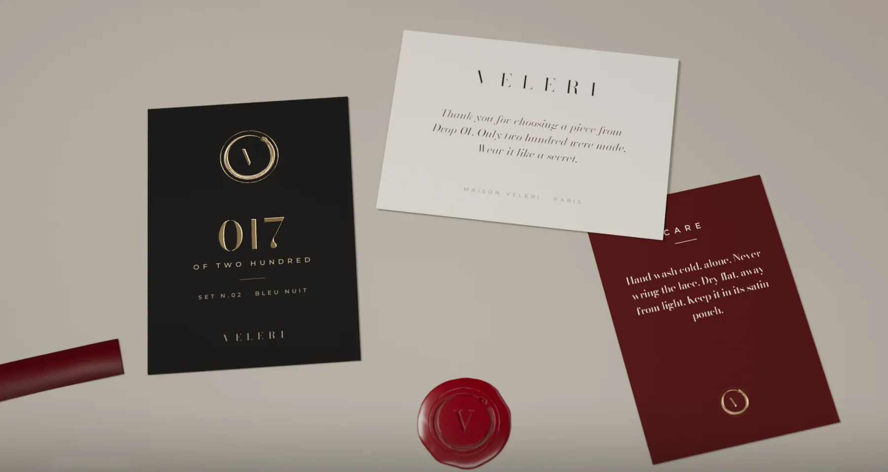 Inside the box: a black numbered card, an ivory thank-you card, an oxblood care card and a wax seal.
